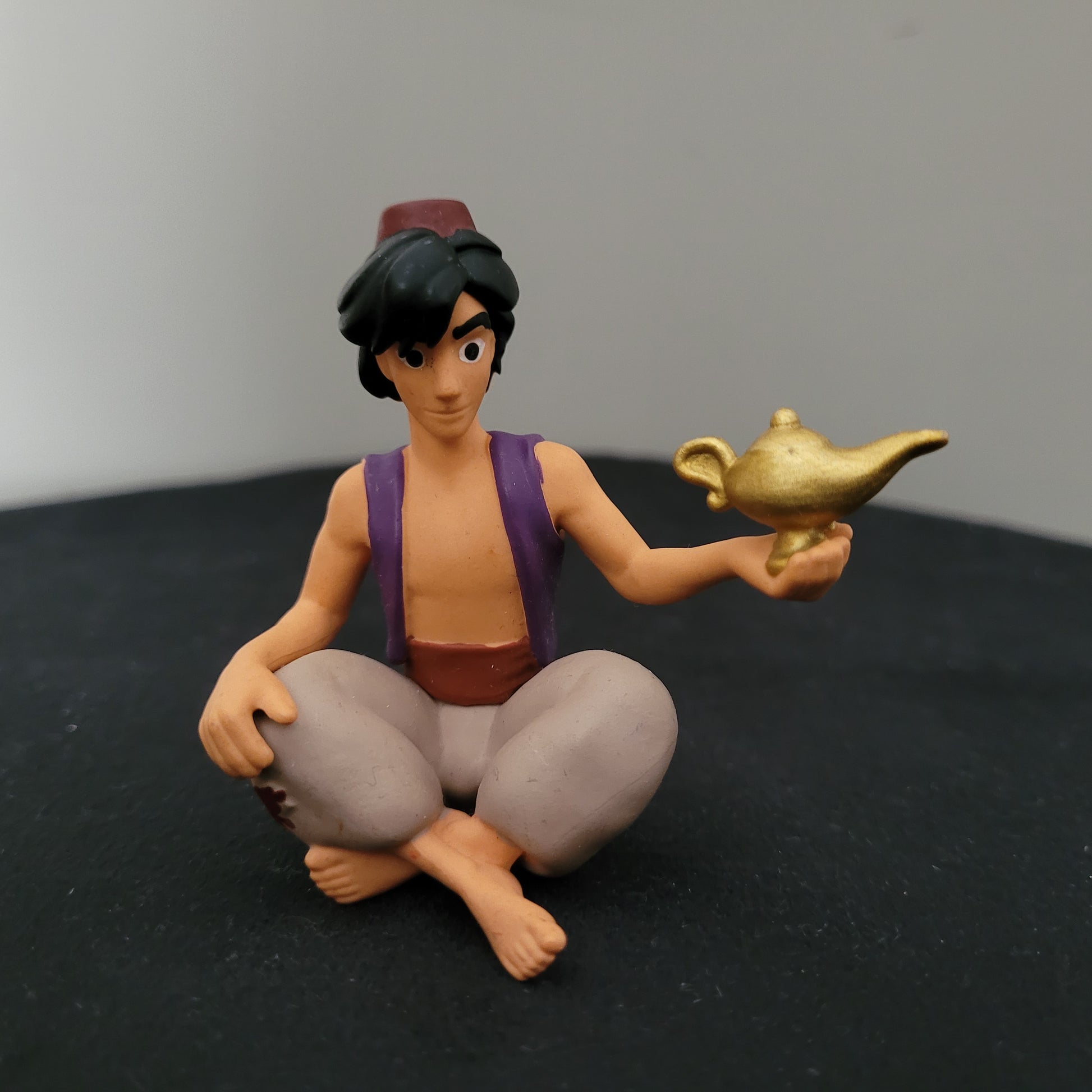 Tonie / Tonies Figur Aladdin. Zu sehen ist die Vorderseite auf schwarzer Oberfläche und grauem Hintergrund.