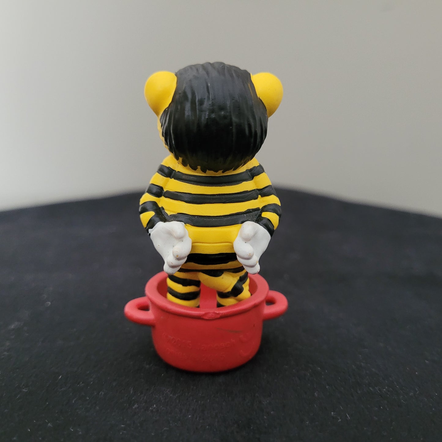 Tonie / Tonies Figur Janosch. Zu sehen ist die Rückseite auf schwarzer Oberfläche und grauem Hintergrund.