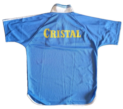 Rückansicht eines blauen Fußballtrikots mit gelbem 'CRISTAL'-Schriftzug und weißem Kragen.