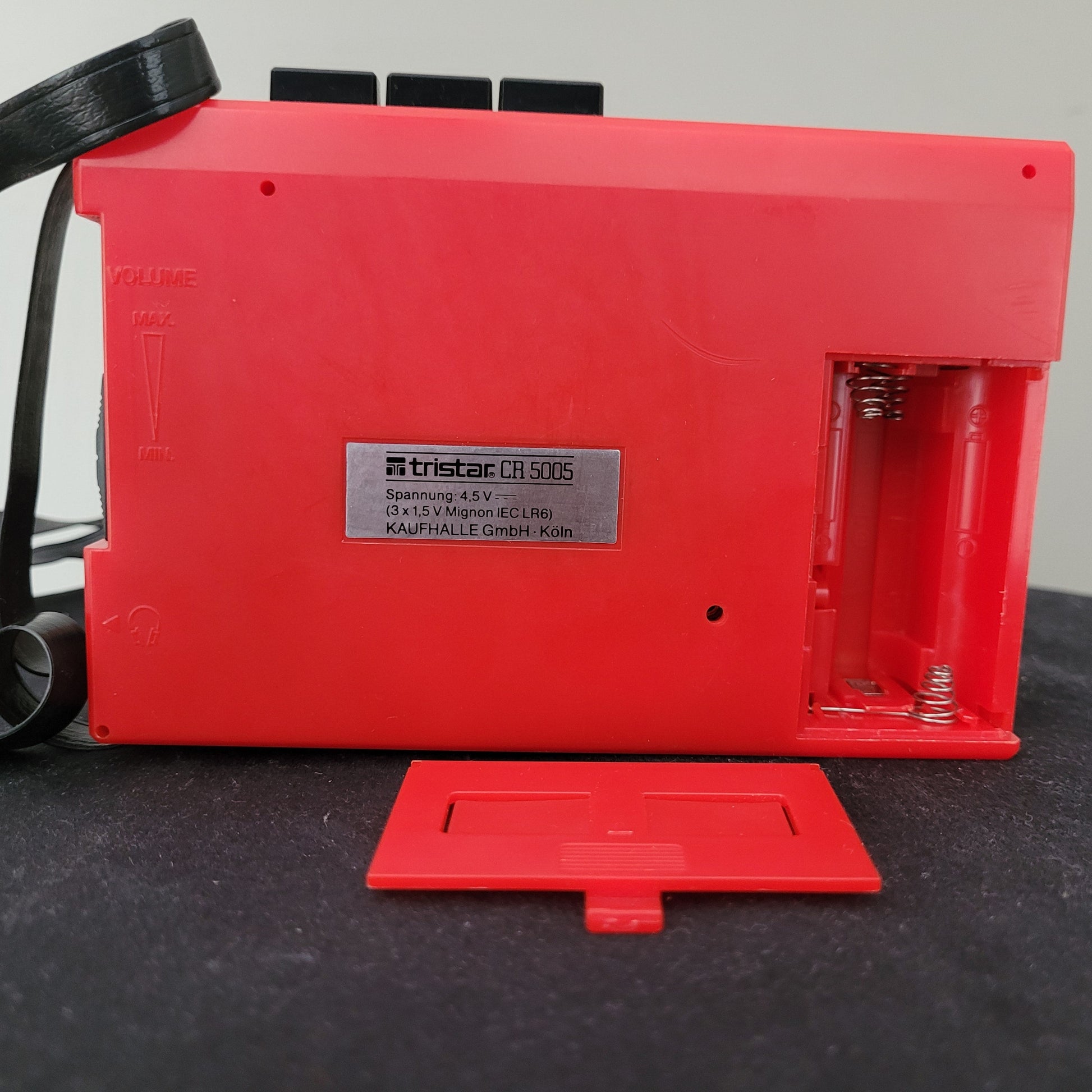 Rückseite des roten Tristar Vintage Walkman CR 5005 mit geöffnetem Batteriefach für 3×1,5V Mignon-Batterien (IEC LR6), sichtbarer Spannungsangabe und seitlichem Lautstärkeregler – klassischer Retro-Kassettenspieler für mobilen Musikgenuss.