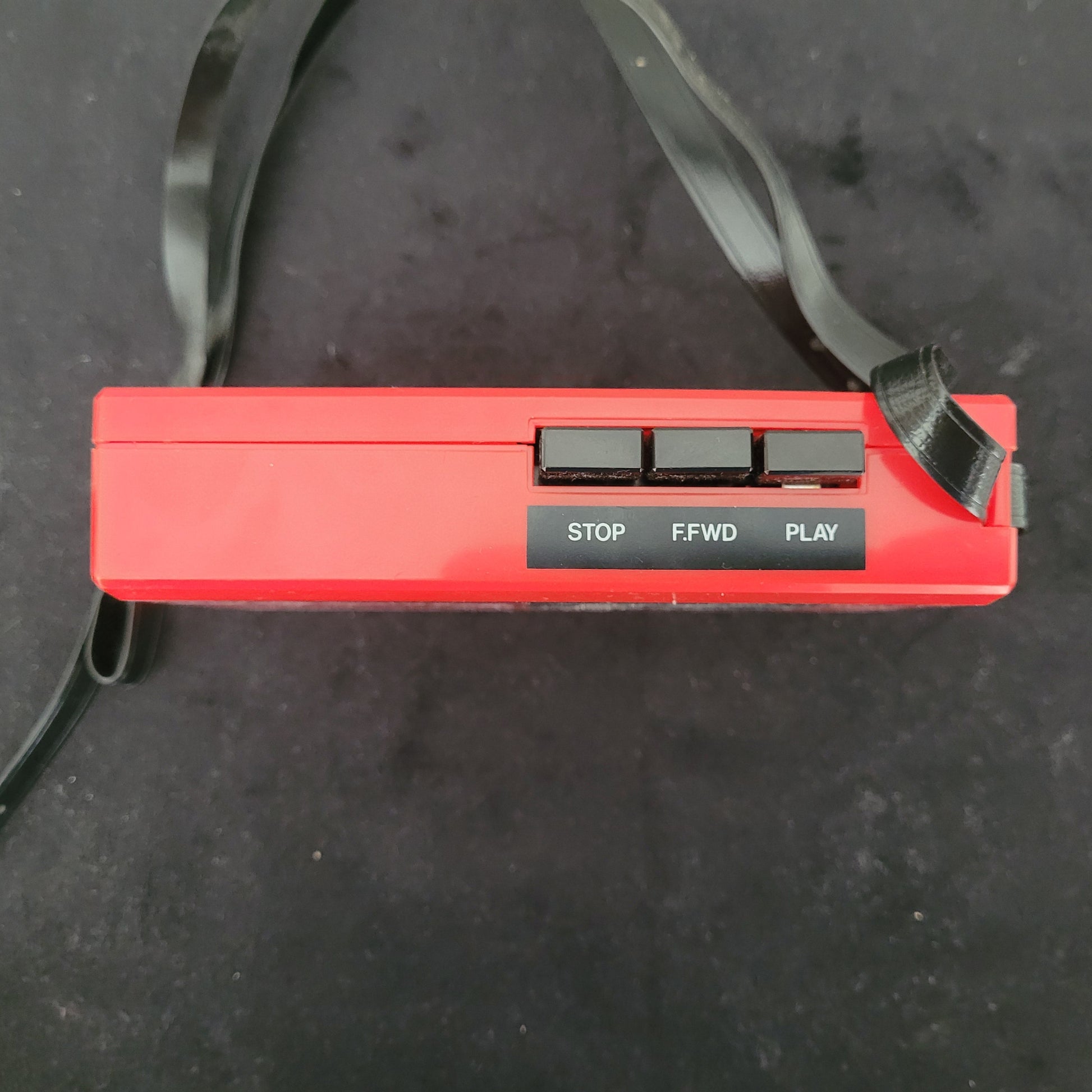 Roter Tristar Vintage Walkman CR 5005 mit schwarzen Bedientasten für STOP, F.FWD und PLAY sowie befestigter Trageschlaufe – tragbarer Retro-Kassettenspieler für nostalgische Audiowiedergabe.