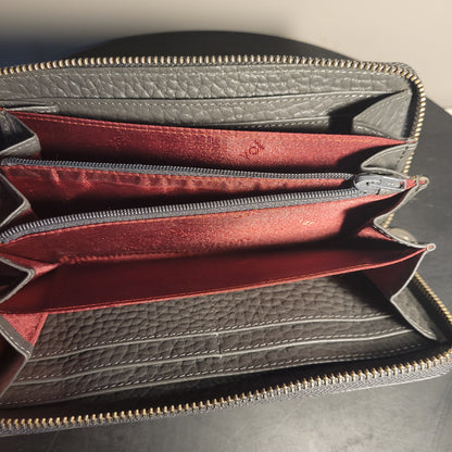 Geöffnete schwarze Leder-Geldbörse von Voi mit rotem Innenfutter, mehreren Kartenfächern und einem grauen Reißverschlussfach, präsentiert auf dunklem Hintergrund.