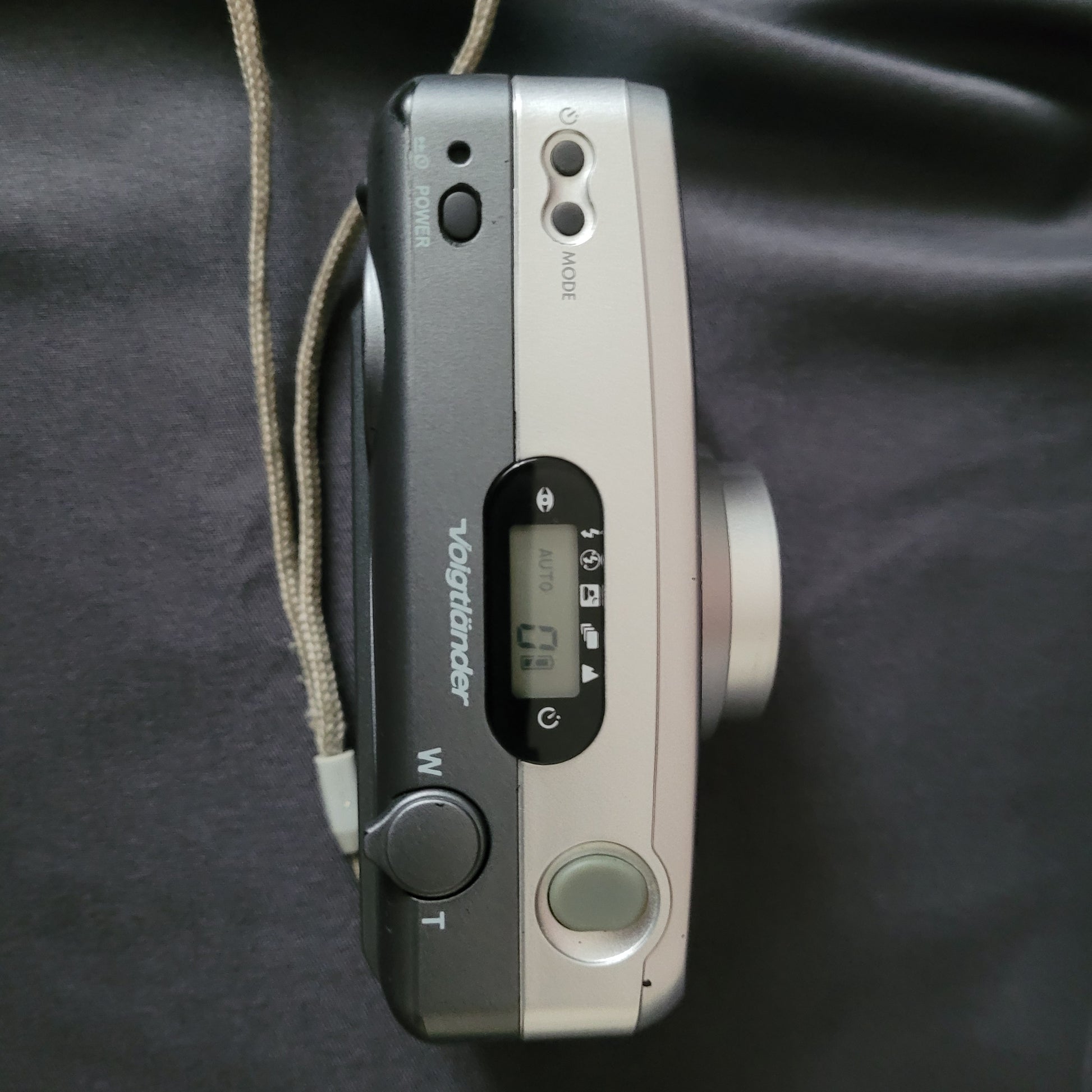 Voigtländer Vitoret AF 35-70 Vintage Analogkamera von oben mit LCD-Display in AUTO-Modus, Power- und Mode-Taste, Zoomsteuerung sowie Auslöser – klassische 35mm Kompaktkamera für Sammler und Liebhaber analoger Fototechnik.