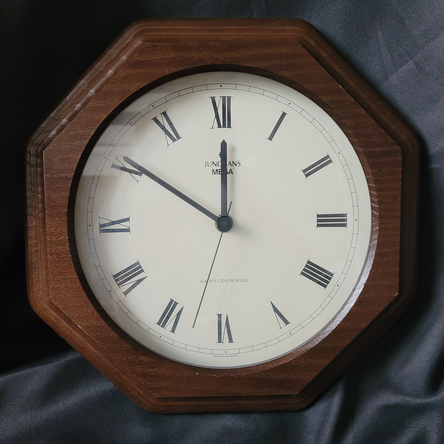 Wanduhr Junghans Mega Radio Controlled Vintage mit achteckigem Holzrahmen, weißem Ziffernblatt und römischen Ziffern, klassische Funkuhr im Retro-Design, dekorative Vintage-Wanduhr für Sammler und Liebhaber.