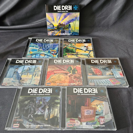 Eine Auswahl an seltenen Hörspiel-CDs und Boxen der Serie Die dr3i aus dem Europa Verlag, ordentlich nebeneinander aufgereiht.