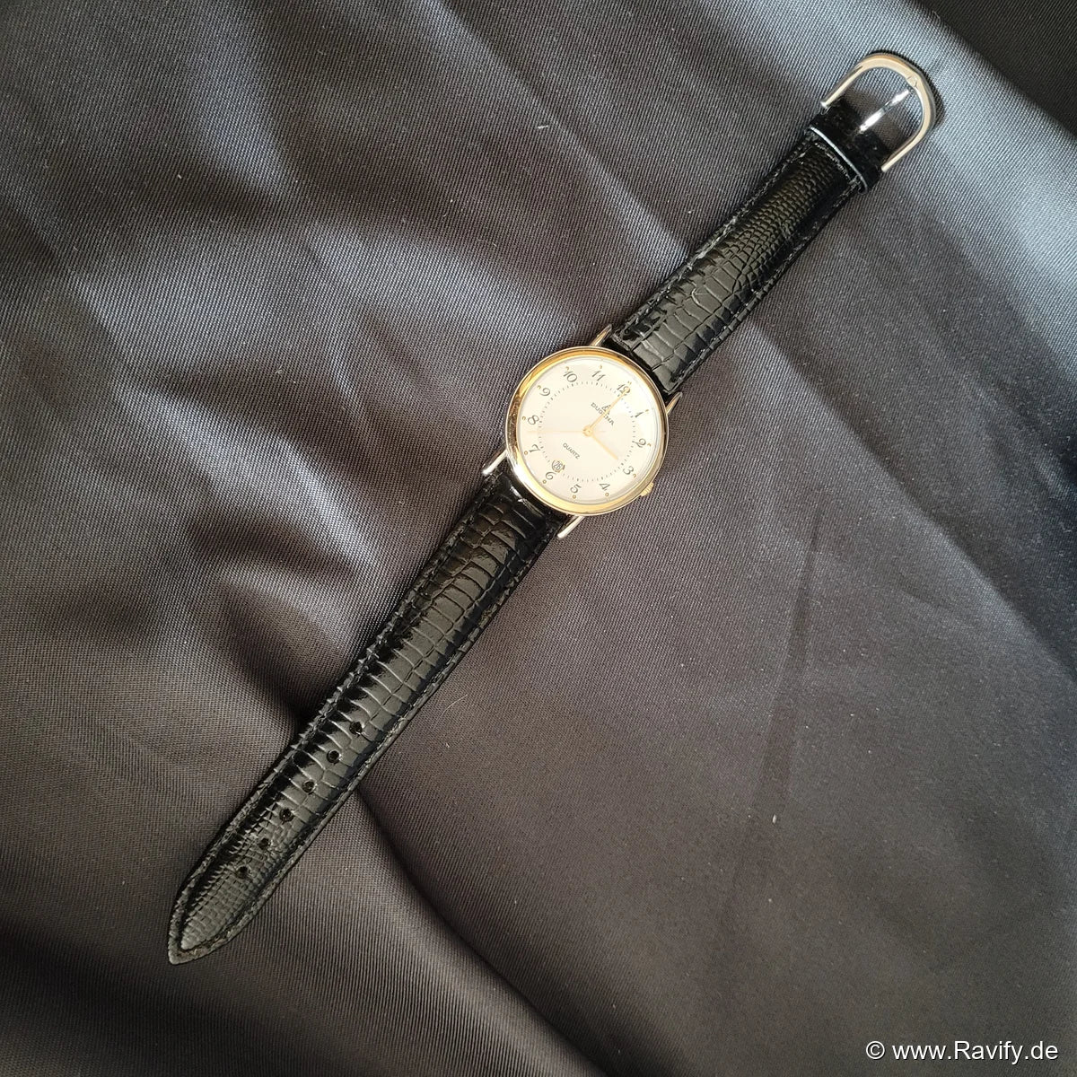 Klassische Vintage Dugena Quartz Armbanduhr für Damen und Herren mit hellem Zifferblatt, silberfarbenem Gehäuse und schwarzem Genuine-Leather-Armband.
