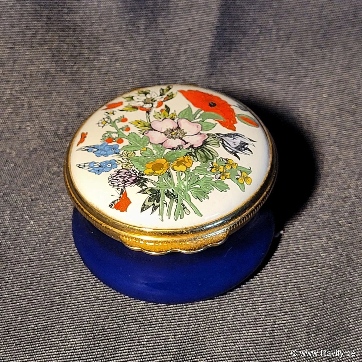 Klassische, runde Halcyon Days Enamels Pillendose in Kobaltblau mit handgemaltem Blumenmotiv auf dem Deckel und feuervergoldeter Fassung.