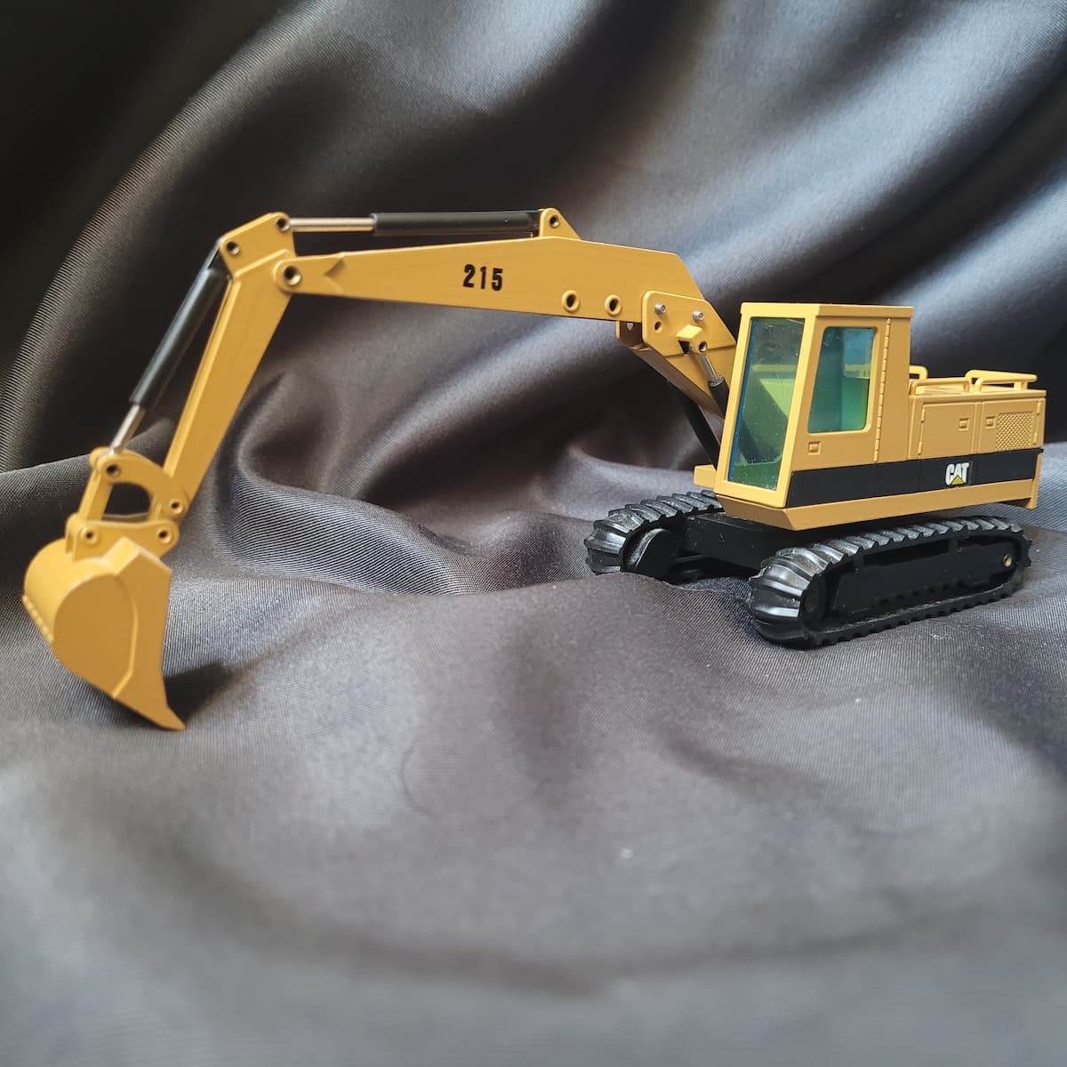 Sammlermodell Caterpillar CAT 215 Hydraulikbagger von NZG, Maßstab 1:50, Modellnummer 190, gelbe Lackierung.