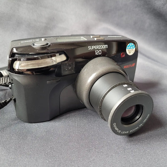 Schwarze Olympus Superzoom 120 Multi AF Analogkamera mit ausgefahrenem Zoom-Objektiv.