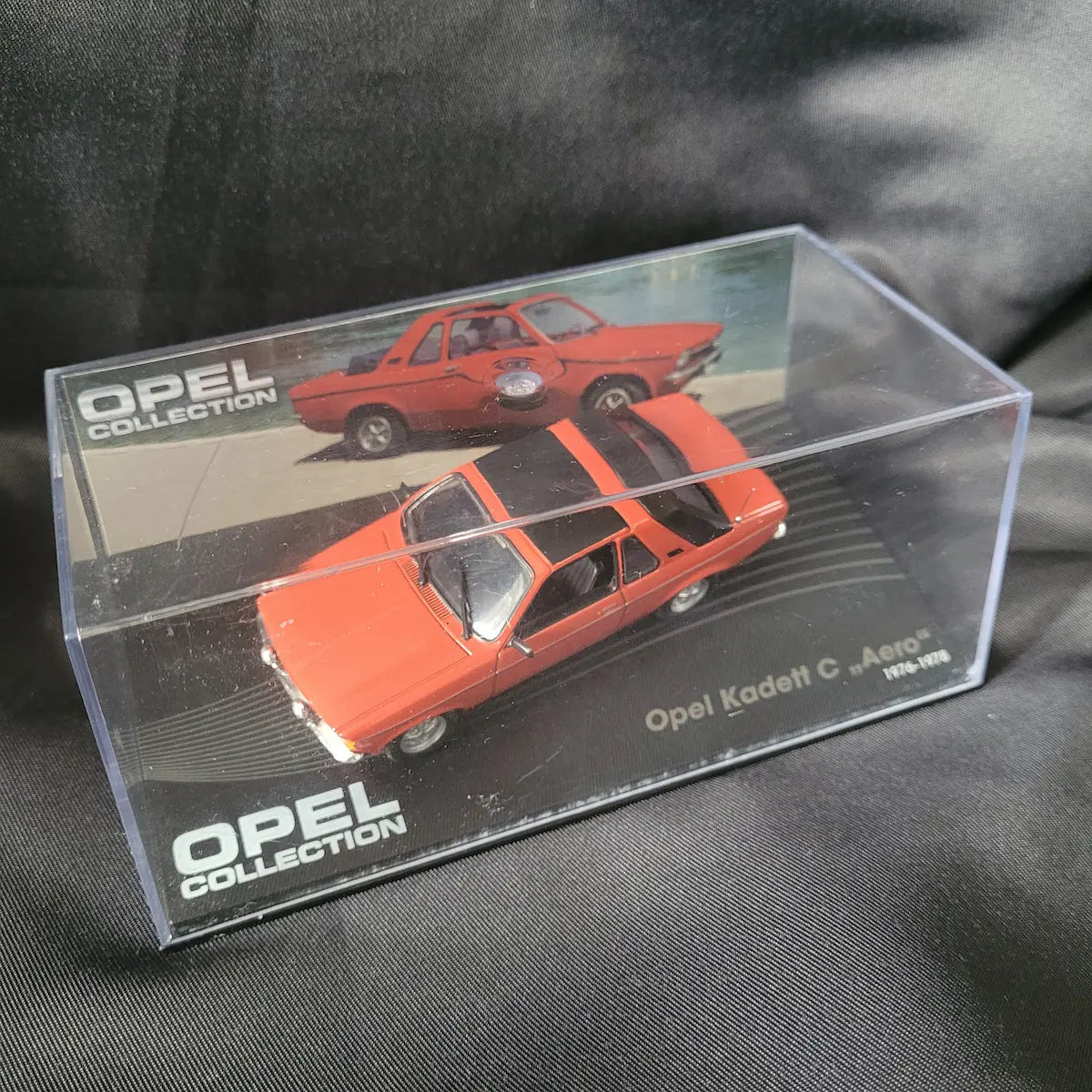Detailliertes Modellauto des Opel Kadett C „Aero“ (1976–1978) in Orange mit schwarzem Targa-Dach im Maßstab 1:43.