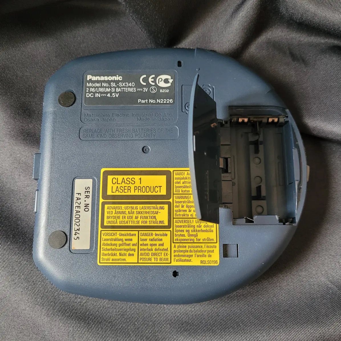 Blau-transparenter Panasonic SL-SX340 Discman mit 48 Sekunden Anti-Skip-System. Rückseite mit offenem Batterieach.