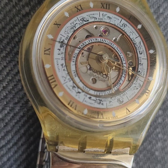 Swatch Automatic Uhr „Time to Move“ von 1993 mit sichtbarem Uhrwerk und astronomischem Zifferblatt.
