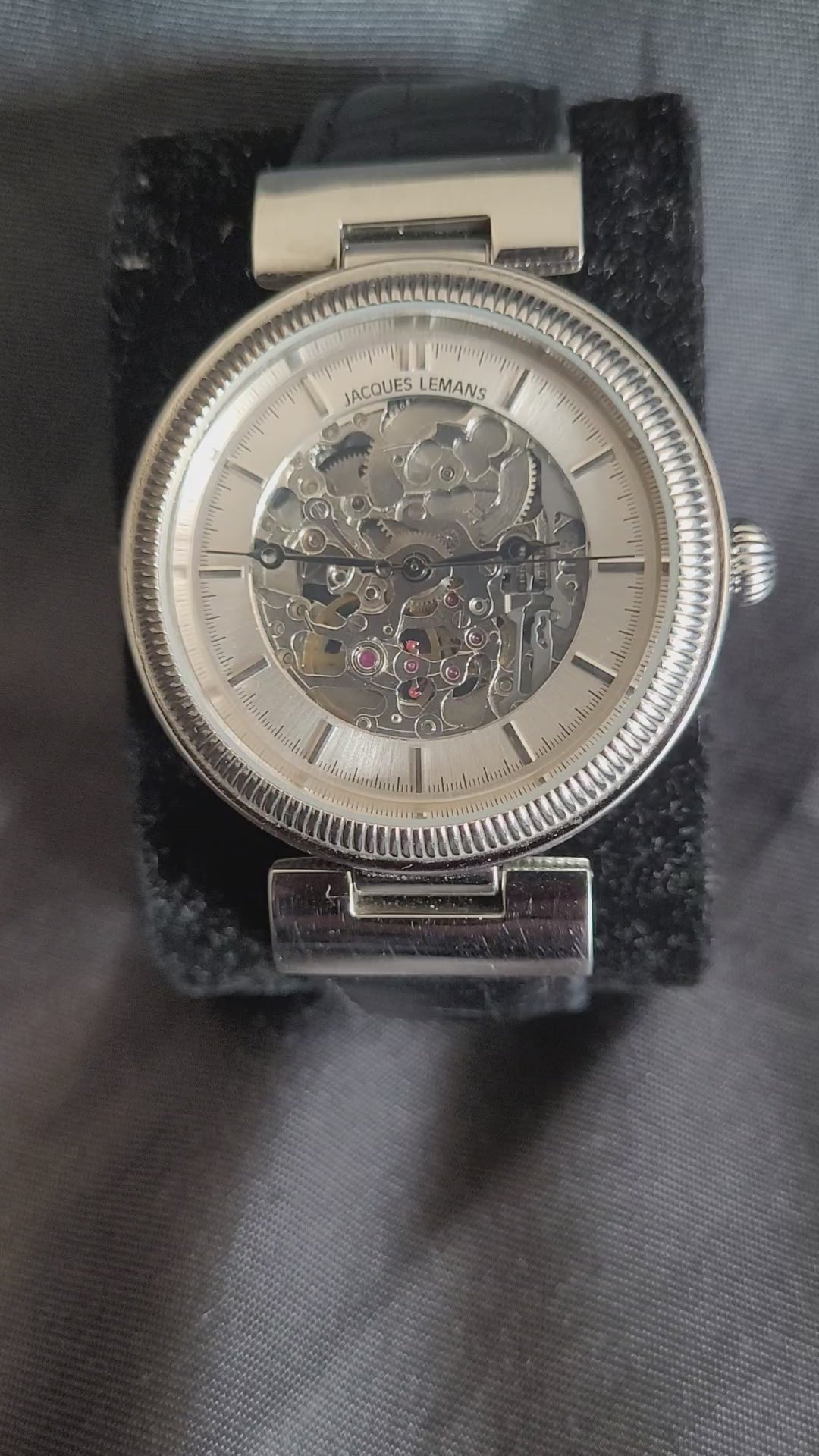Video-Faszination Mechanik: Jacques Lemans Automatik 1-1212 Skelett-Herrenuhr mit poliertem Edelstahlgehäuse und transparentem Einblick in das Uhrwerk.