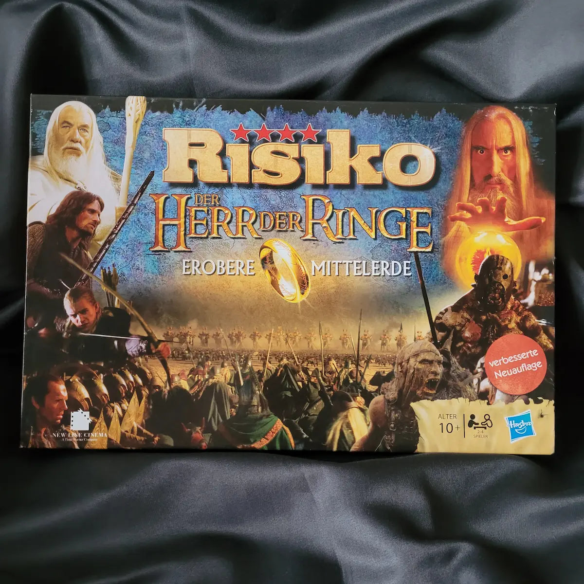 Vorderseite der Spielebox von Risiko – Der Herr der Ringe (verbesserte Neuauflage) mit Motiven aus der Filmtrilogie.