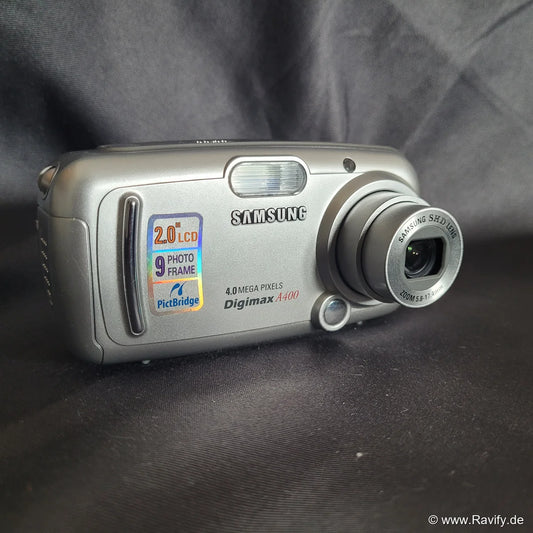 Kompakte silberne Samsung Digimax A400 Y2K-Digitalkamera mit 4.0 Megapixeln, ausfahrbarem Zoom-Objektiv und 2.0 Zoll LCD-Display.