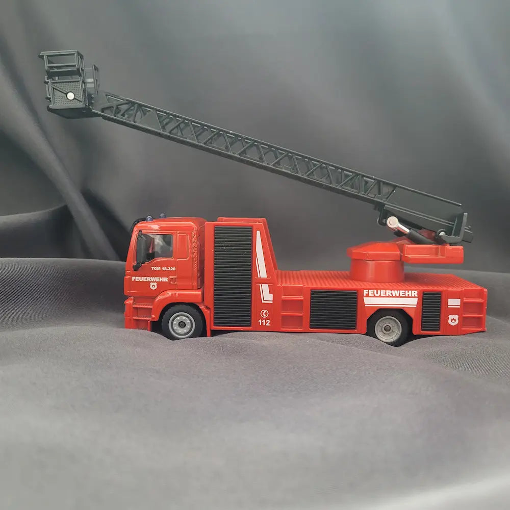 Rote SIKU 2114 Feuerwehr Drehleiter auf MAN TGM Fahrgestell im Maßstab 1:50 mit ausgefahrener Leiter. Seitenansicht links.