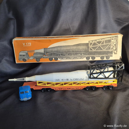 Siku V-Serie V179 Raketentransporter mit blauer Zugmaschine, orangefarbenem Auflieger, Atlas-Rakete und Originalschachtel (OVP)