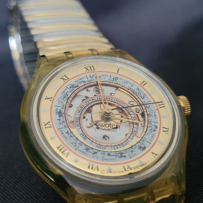 Vorderseite der Swatch Automatic Uhr „Time to Move“ von 1993 mit sichtbarem Uhrwerk und astronomischem Zifferblatt.