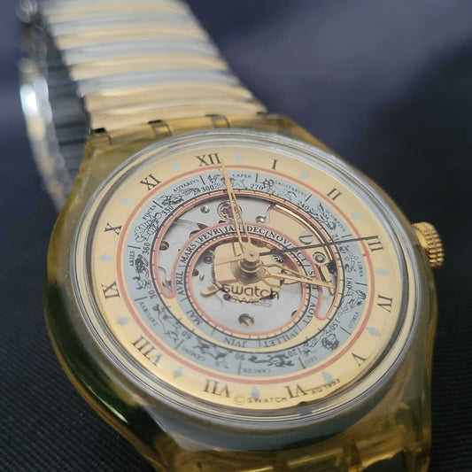 Vorderseite der Swatch Automatic Uhr „Time to Move“ von 1993 mit sichtbarem Uhrwerk und astronomischem Zifferblatt.