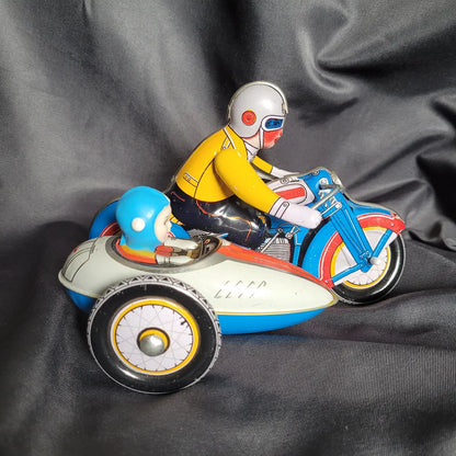 Klassisches Blechspielzeug-Motorradgespann in Grün mit Beiwagen und detaillierter lithografierter Fahrerfigur im Vintage / Retro-Look.