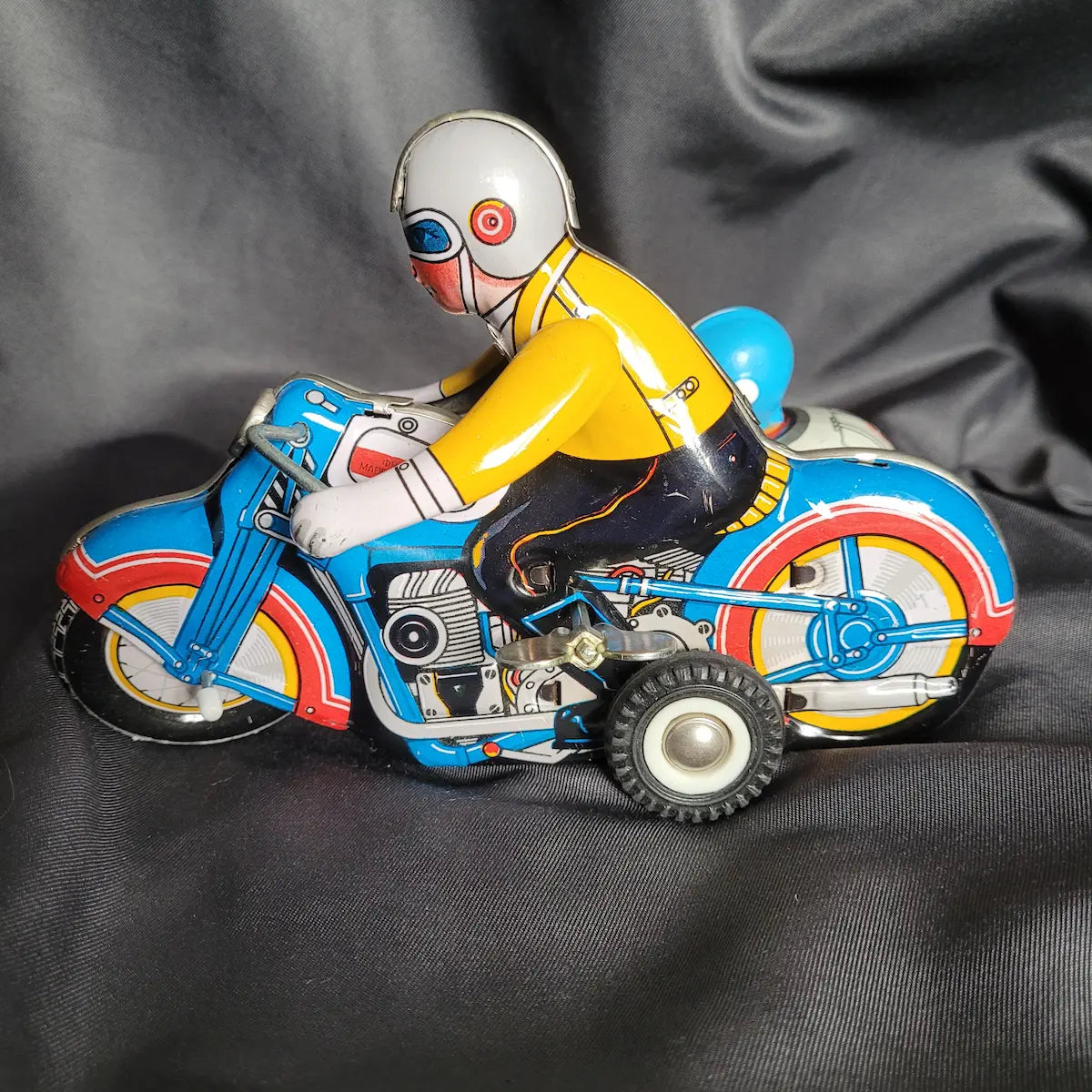 Klassisches Blechspielzeug-Motorradgespann in Grün mit Beiwagen und detaillierter lithografierter Fahrerfigur im Vintage / Retro-Look.