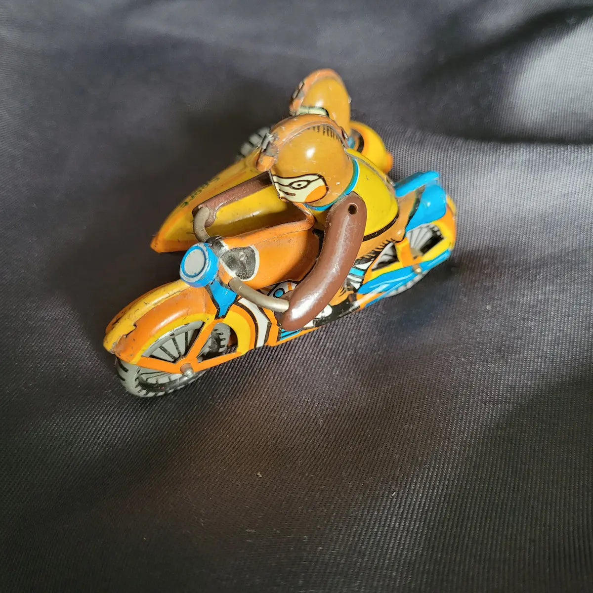 Klassisches, orange-gelbes Miniatur-Blechspielzeug Motorradgespann mit Beiwagen und dem Logo ZZ Germany auf der Unterseite.