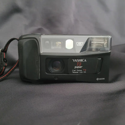 Vorderansicht der schwarzen Yashica T3 Super Point-and-Shoot Analogkamera mit sichtbarem Carl Zeiss Tessar Objektiv.